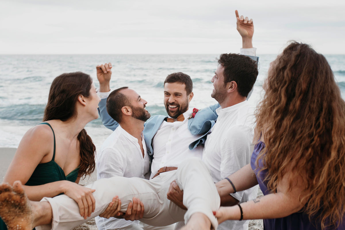 Best clothing rental for men at weddings: groom celebrating with guests in casual wedding attire